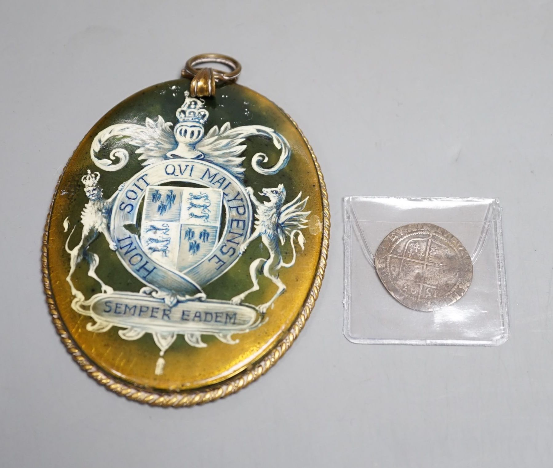 An Elizabeth I 1593 sixpence and a oval portrait frame the reverse depicting Elizabeth I coat of arms.